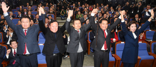 황교안(가운데) 자유한국당 대표가 9일 서울 여의도 국회에서 열린 의원총회에서 신임 원내대표로 선출된 심재철(오른쪽 두번째) 의원과 김재원(왼쪽 두번째) 신임 정책위의장 등과 손을 잡고 기념촬영을 하고 있다.   연합뉴스